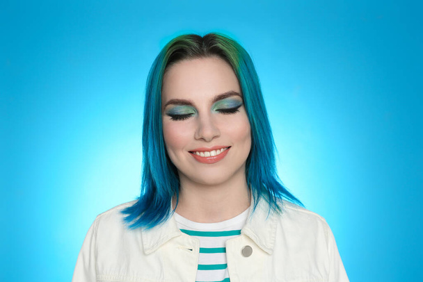 Junge Frau mit hell gefärbten Haaren auf hellblauem Hintergrund - Foto, Bild