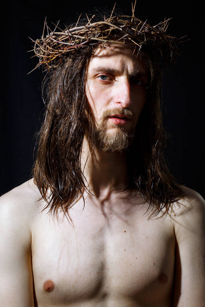 Triste Jesucristo con corona de espinas sobre fondo negro
 - Foto, Imagen