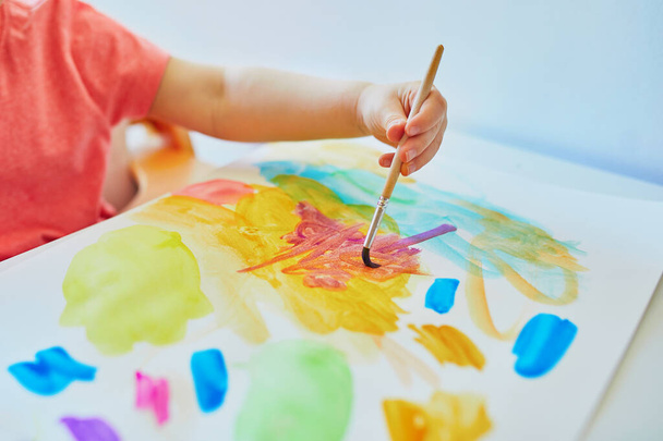 Girl drawing with colorful aquarelle paints at home, in kindergaten or preschool. Creative games, education and distance learning for kids. Stay at home entertainment - Φωτογραφία, εικόνα