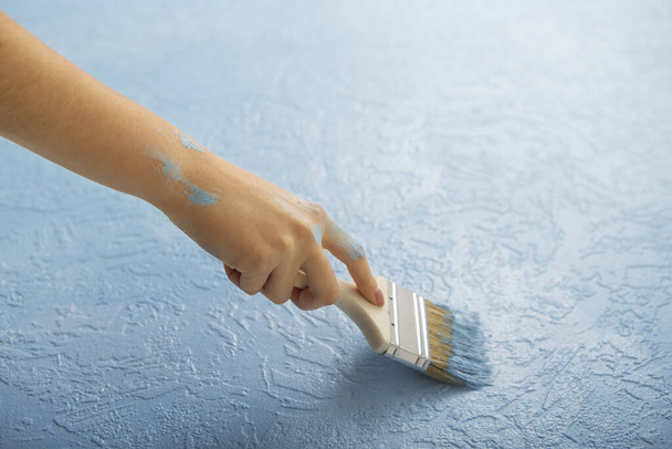 Käsintehty korjaus kotona. Nainen maalaa siveltimellä
 - Valokuva, kuva