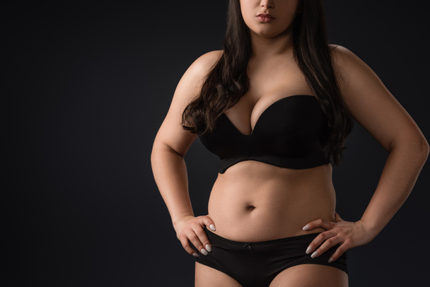 Cropped view of young size plus woman in underwear on black background - Photo, Image