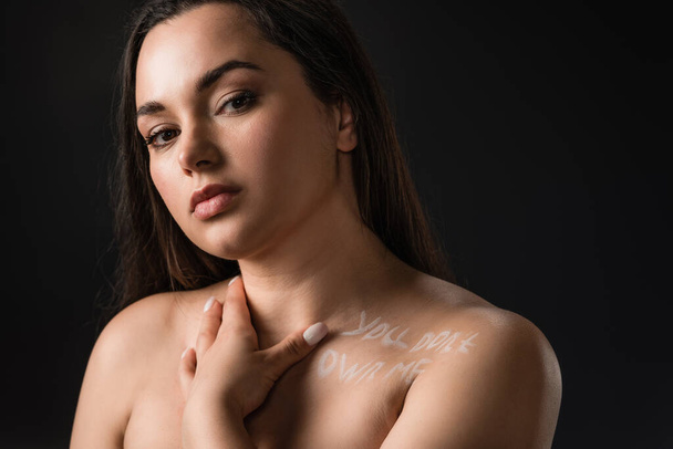 Portrait of pretty plus size girl with lettering You Don't Own Me on body isolated on black - Foto, Bild
