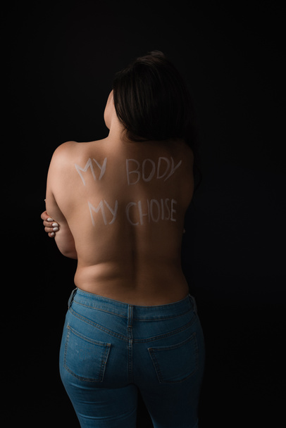 Back view of plus size model with lettering My Body My Choice on body isolated on black  - Photo, Image