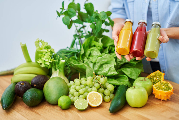 Fles smoothie oresh groene groenten en fruit op houten aanrecht - Foto, afbeelding