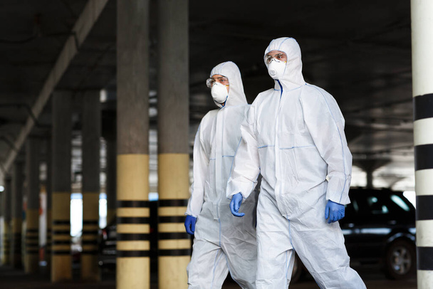 Medical workers in protective mask and suits going in empty city - Photo, Image
