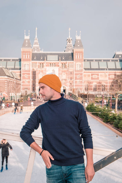 アムステルダム市オランダアイスリンク｜アムステルダム国立美術館オランダの冬の明るい日に、若い男性が冬の間にアムステルダムを訪問 - 写真・画像