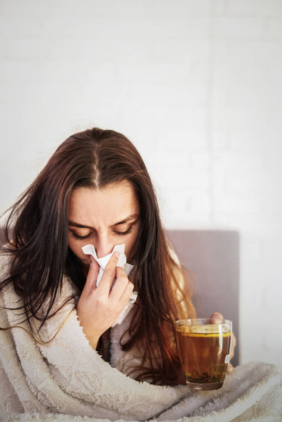 Blurred young woman is feeling bad and sick lying in the bed at home. Girl has symptoms of respiratory viral infection, fever, cough. Coronavirus covid-19 epidemic pandemic concept. - Foto, Imagen