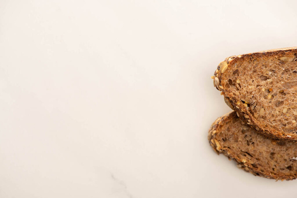 top view of fresh brown bread slices on white background - Zdjęcie, obraz