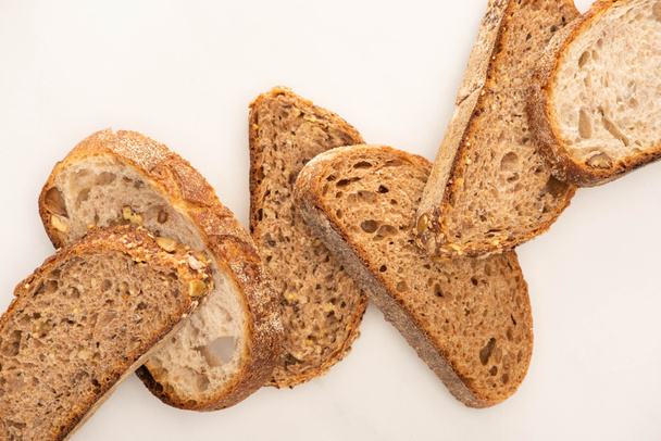 vista superior de fatias de pão de grão inteiro fresco no fundo branco
 - Foto, Imagem