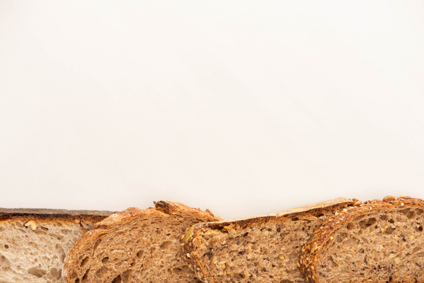 コピースペースのある白い背景に新鮮な全粒パンのスライスのトップビュー - 写真・画像