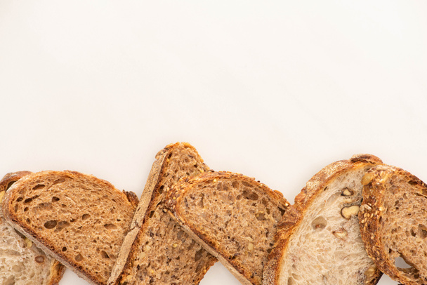 верхний вид цельного зерна ломтики хлеба на белом фоне с копировальным пространством
 - Фото, изображение