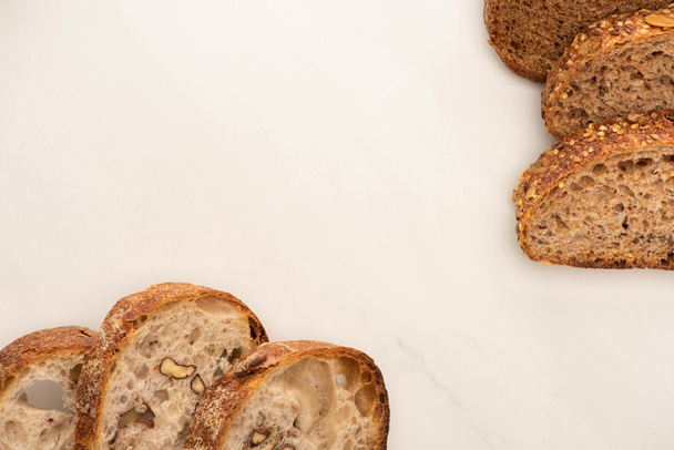 top view of fresh whole wheat bread slices on white background with copy space - Fotoğraf, Görsel