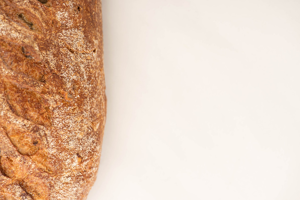 vrchní pohled na čerstvé celozrnný chléb bochník na bílém pozadí s kopírovacím prostorem - Fotografie, Obrázek