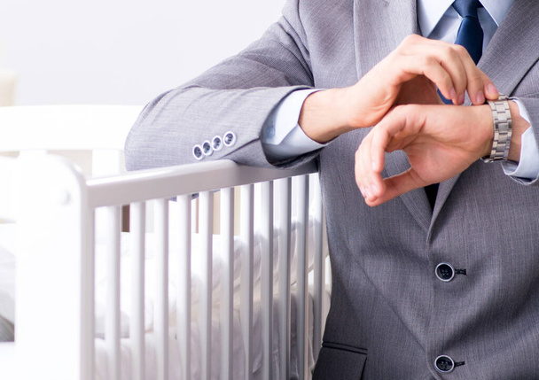 Jonge zakenman probeert te werken vanuit huis zorg na pasgeboren - Foto, afbeelding