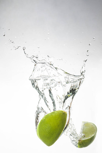 lime in water and beautiful spray - Fotó, kép