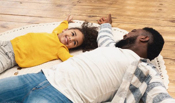 Gülümseyen Afrikalı Amerikalı baba ve kızı evde kalıyor. - Fotoğraf, Görsel