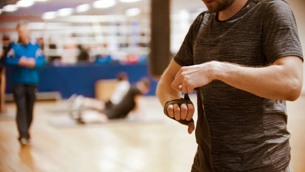 Un boxeador hombre atando su mano antes del entrenamiento en el gimnasio
 - Foto, Imagen