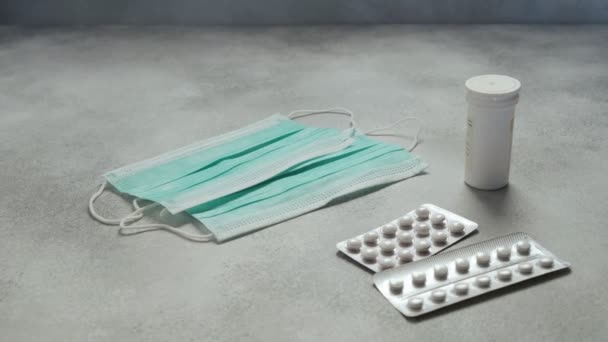 Lékařské masky, léky pilulky, kapsle, injekční lahvička na betonovém pozadí. zdravotní - Záběry, video