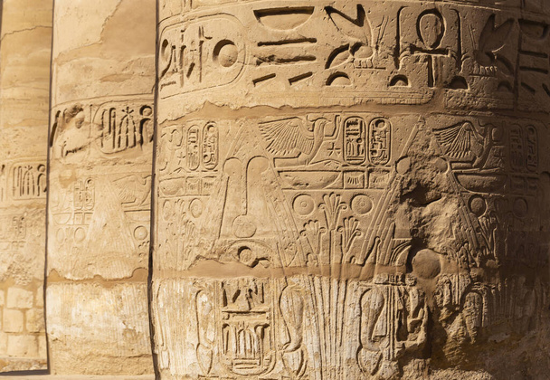 Karnak Tempel, complex van Amun-Re. Grote Hypostyle Hall. Hiërogliefen in reliëf op kolommen. Luxor Governorate, Egypte. - Foto, afbeelding
