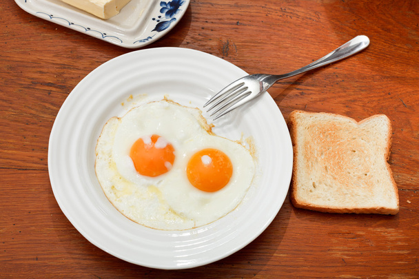 Breakfast with two fried eggs in white plate - Foto, Bild