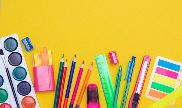 Office supplies on a yellow background. Various school supplies on a bright yellow background. Text frame with office supplies. The layout of the school. Welcome back to school. Concept of advertising office supplies. Flat lay with space for text. - Foto, immagini