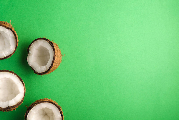 Kokosové ovoce na zeleném prostém pozadí, abstraktní jídlo tropické koncepce, horní pohled kopírovat prostor - Fotografie, Obrázek