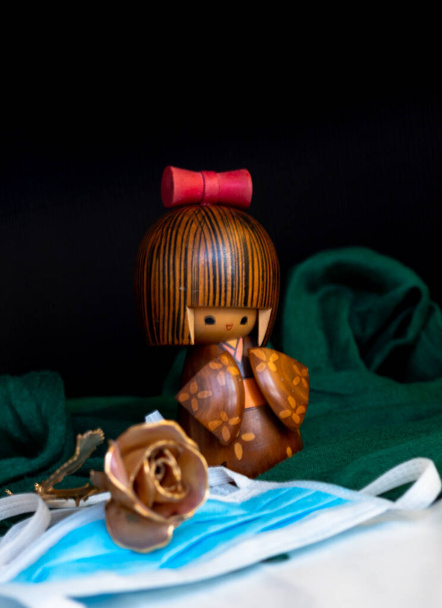 figuras de madera china con una rosa y máscara como homenaje a las víctimas y la curación del virus covid19
 - Foto, Imagen