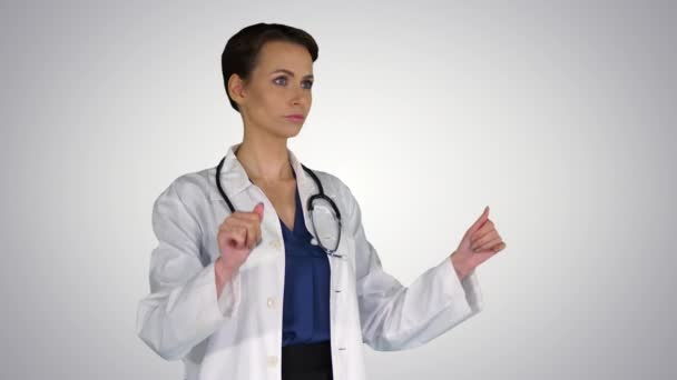 Healthcare, medicine and technology concept - smiling female doctor pointing to something or pressing imaginary buttons on gradient background. - Video, Çekim