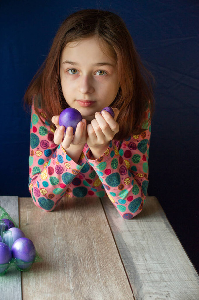 Счастливой Пасхи. Девушка и цветные яйца в фиолетовом. Традиции Пасхи. Подросток, девочка 9 лет. Девушка с шарлатаном. Ребёнок в платье в горошек. Праздники, весна
 - Фото, изображение
