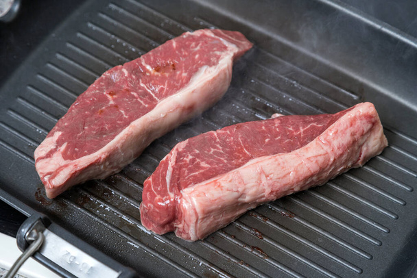 Pieces of beef are cooked in a frying pan. Rich and juicy steaks. Cooking meat. - Photo, Image
