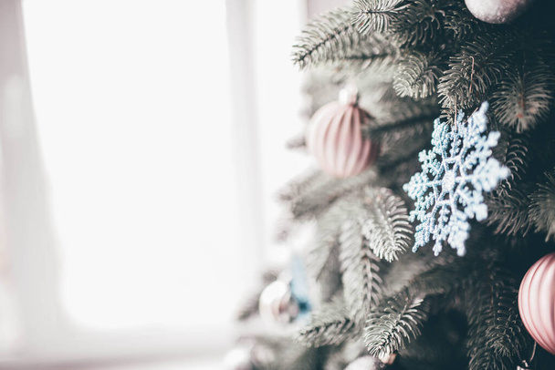 Image d'arbre de Noël vert décoré près de la fenêtre. Lumière du jour. Jouets colorés pour la décoration. Chambre vide sans personnes
. - Photo, image