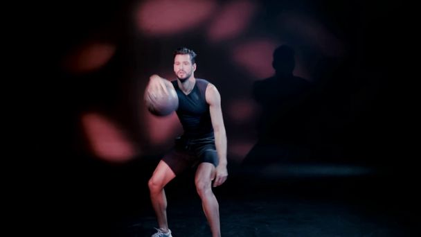 Sportsman playing basketball on dark background - Metraje, vídeo