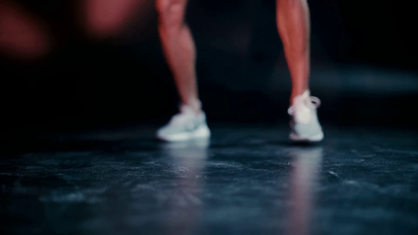 Oříznutý pohled na sportovce cvičit s míčem na tmavém pozadí - Záběry, video
