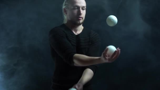 Man wearing a black juggling with white balls. Management, control and success - Imágenes, Vídeo
