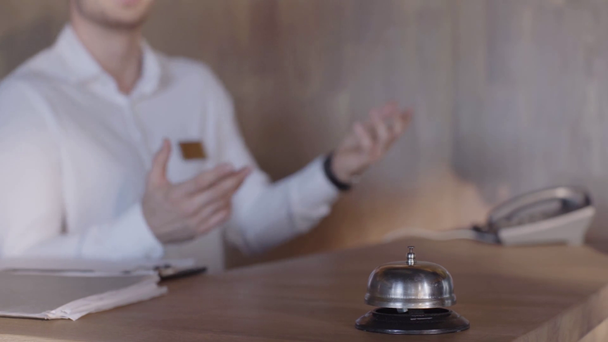 przycięty widok klienta naciskając dzwonek usługi w pobliżu recepcjonistki hotelu - Materiał filmowy, wideo