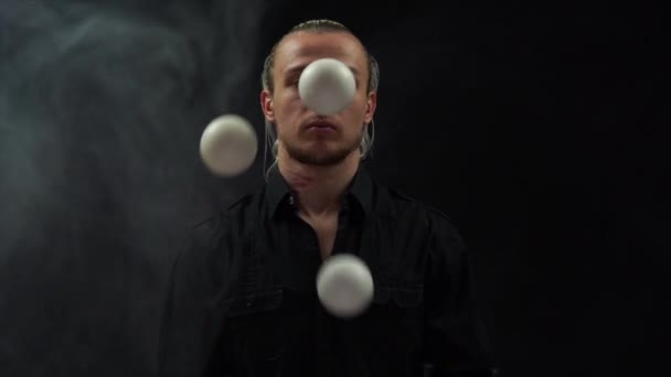 Man wearing a black juggling with white balls. Management, control and success - Imágenes, Vídeo