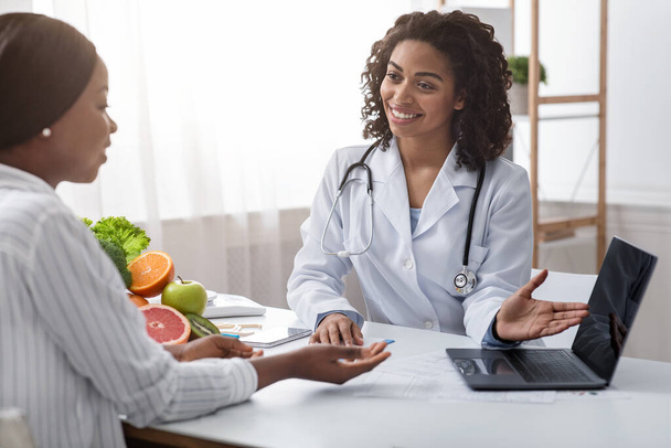 Smiling female doctor nutritionist having conversation with her patient - Photo, Image