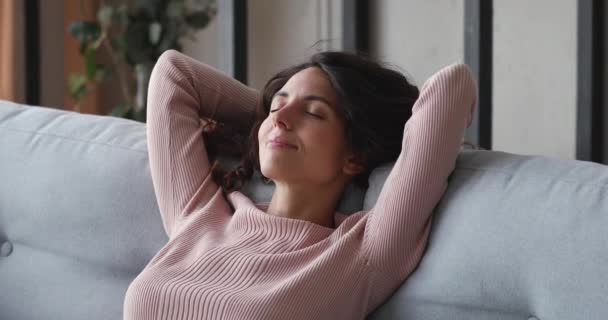 Happy relaxed single lady resting on comfortable sofa at home - Filmati, video