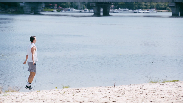 Nehir kenarında ip atlayan genç sporcunun yan görüntüsü - Video, Çekim