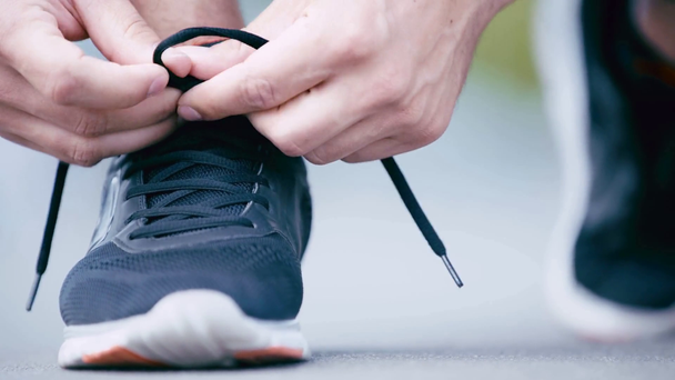 ostříhaný pohled sportovce vázání tkaniček na tenisky - Záběry, video
