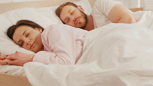 Επιλεκτική εστίαση της γυναίκας που κοιμάται στο κρεβάτι κοντά στο φίλο  - Πλάνα, βίντεο