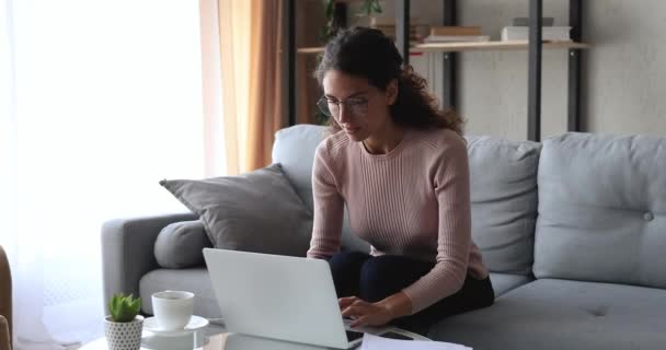 Overjoyed young woman using laptop reading great news at home - Záběry, video