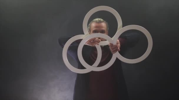 Homme portant un noir manipulant avec des anneaux blancs. concentration et attention
 - Séquence, vidéo