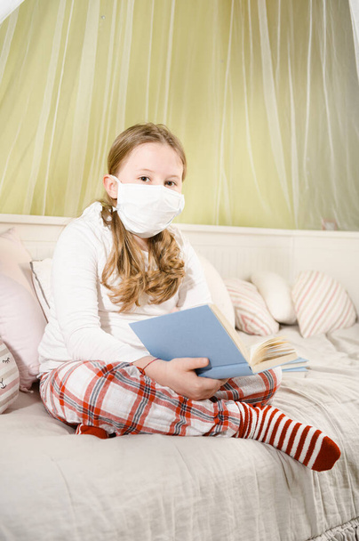 Girl reading a book during quarantine on the bed. - Valokuva, kuva