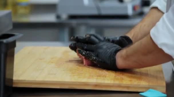 hands in rubber gloves crumple minced meat on a wooden board - Video, Çekim