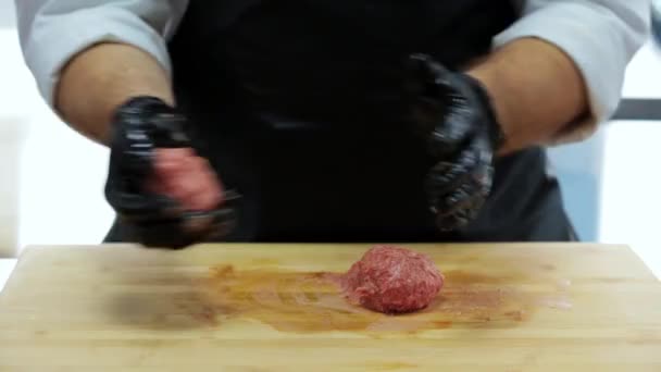 hands in rubber gloves crumple minced meat on a wooden board - Materiał filmowy, wideo