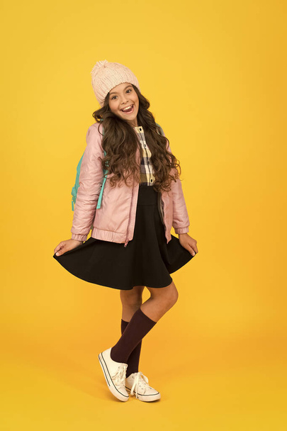 Stylish for extra seasonal warmth. Stylish girl back to school. Little child in stylish autumn wear yellow background. Give your school wardrobe stylish look. Fashion and style - 写真・画像