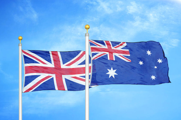 Wielka Brytania i Australia dwie flagi na maszcie flagowym i niebieskie zachmurzone tło nieba - Zdjęcie, obraz