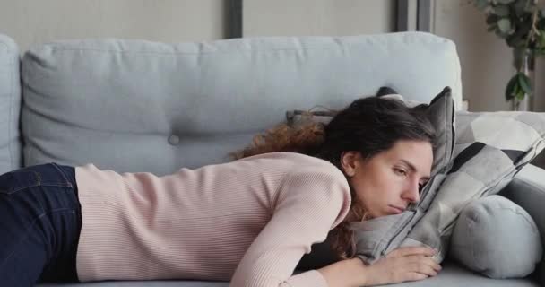 Mujer cansada o aburrida joven soñolienta cae en el sofá - Metraje, vídeo