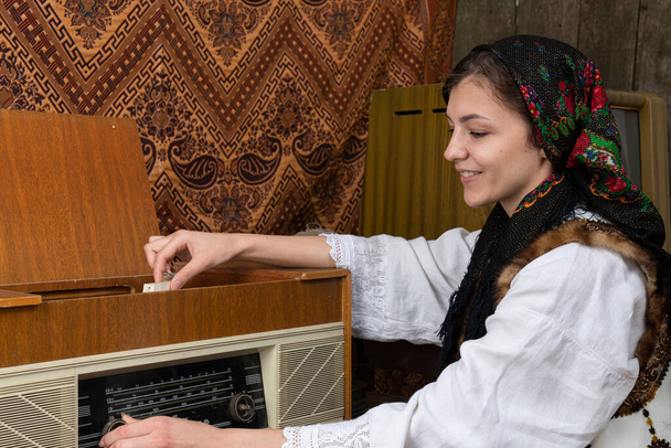 Щаслива дівчинка-посмішка в українець національний одяг слухати музику на ретро радіо - Фото, зображення